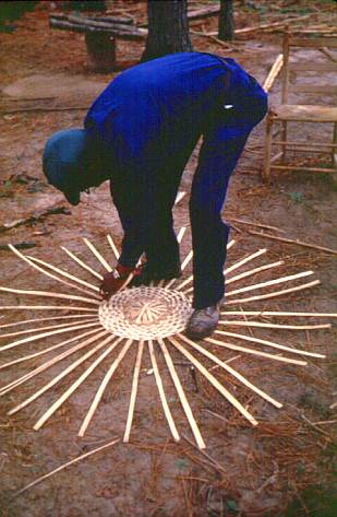 Many basketmakers like Sidney Reed of Haynesville begin by laying the ribs of the split white oak basket on the ground which form the frame of the basket.